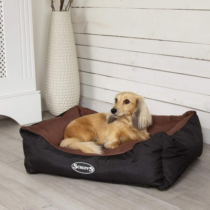 Elevate your pet's comfort with the Scruffs Expedition Box Dog Bed, designed to withstand the rigors of outdoor adventures while maintaining a stylish edge. Chocolate